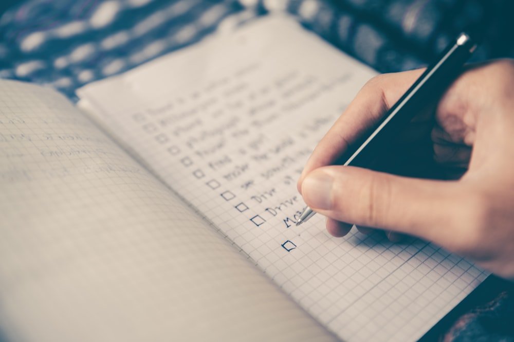 Description: person writing bucket list on book